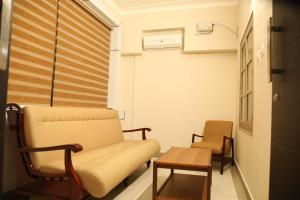 a waiting room with a couch and a table at Kalathil Kshetra Inn in Guruvāyūr +57 photos