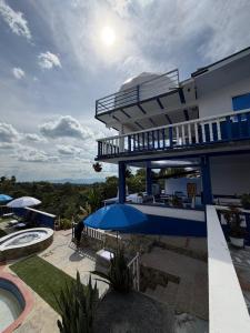 a house with a balcony and a swimming pool at Arte Hotel del Quindío in Filandia