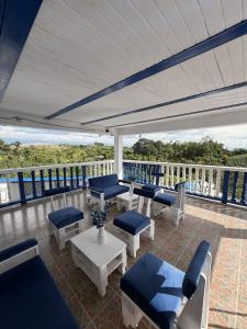 a porch with blue chairs and tables and a white roof at Arte Hotel del Quindío in Filandia