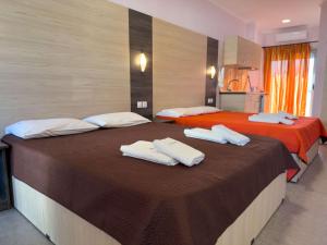 two beds in a hotel room with towels on them at Villa Georgia beach in Neos Marmaras