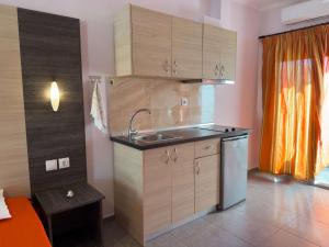 a kitchen with wooden cabinets and a sink at Villa Georgia beach in Neos Marmaras