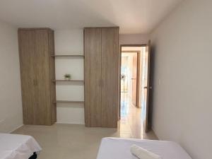 a room with a bed and shelves and a hallway at San gil plaza confort in San Gil