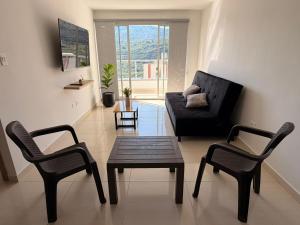 a living room with a couch and two chairs and a table at San gil plaza confort in San Gil
