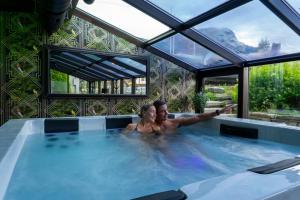 Ein Mann und eine Frau in einem Whirlpool in der Unterkunft Skogstad Hotel - Unike Hoteller in Hemsedal