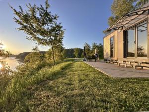 a building with benches next to a river at Feriendorf Seeblick - Tiny Chalet Nr 9 in Neunburg vorm Wald