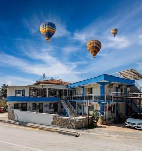 three hot air balloons flying over a house at Aspawa Hotel in Pamukkale