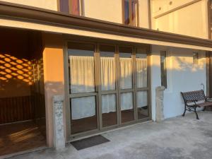 a glass door with a bench next to a building at Corte Galassi in Torsa