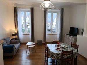 a living room with a table and a couch at Les Gîtes d'Altaïr - La Petite Ourse in Tarascon-sur-Ariège