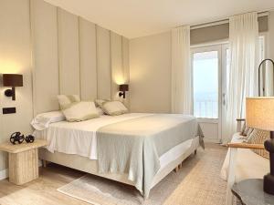 a bedroom with a large bed and a window at Beachfront Luxury Villa in O Grove