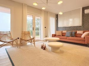 a living room with a red couch and chairs at Beachfront Luxury Villa in O Grove