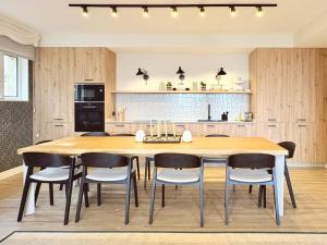 a kitchen and dining room with a wooden table and chairs at Beachfront Luxury Villa in O Grove