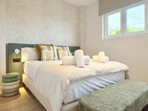 a bedroom with a large white bed and a window at Beachfront Luxury Villa in O Grove +16 photos
