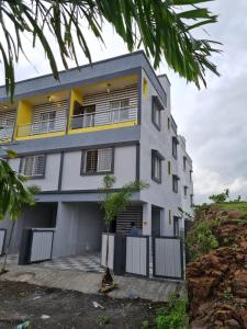 a building with a man standing in front of it at Umahomestay in Nashik