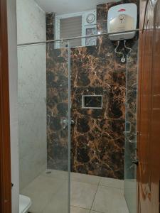 a bathroom with a glass shower with a toilet at Prysm Homestay - Kotagiri in Kotagiri