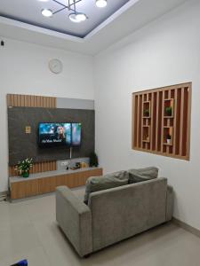 a living room with a couch and a flat screen tv at Sukabumi Villa Mochi Private Jacuzzi in Sukabumi