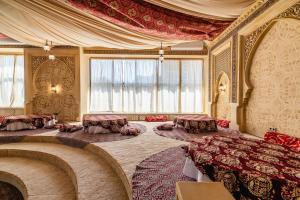 a room with two beds and tables in it at Alladin Capsule Hotel in Almaty