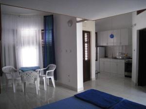 a kitchen and dining room with a table and chairs at Vila Familija in Dobra Voda