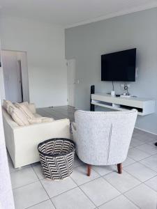 a living room with a couch and a tv at Capri Horizon Hideaway in Fish Hoek