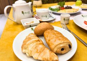 a white plate with croissants and bread on a table at Hôtel La Pivoine in Abidjan