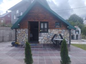 a log cabin with a table in front of it at Vikendica Pejovic in Žabljak
