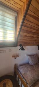 a bed in a room with a wooden ceiling at Vikendica Pejovic in Žabljak
