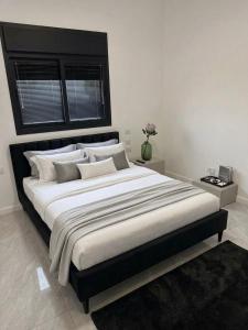 a bedroom with a large bed with a black headboard at פנטהאוז Siesta in Eilat