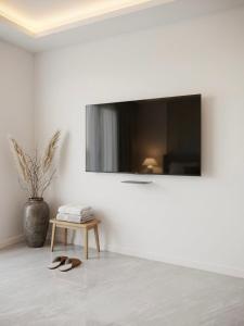 a living room with a tv on a white wall at פנטהאוז Siesta in Eilat +2 photos