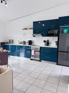 a kitchen with blue cabinets and a white tile floor at Capri Horizon Hideaway in Fish Hoek