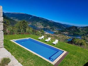 a swimming pool in a yard with two lawn chairs at Casa Sambinho II Bela Vista in Rio Caldo
