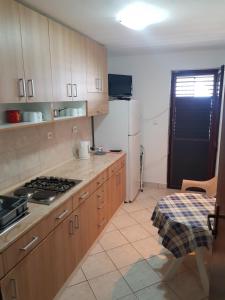 a kitchen with wooden cabinets and a stove top oven at Vila Familija in Dobra Voda +39 photos