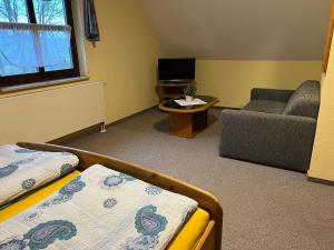 a living room with a bed and a couch at Gästezimmer Rittergut Inh. Christian Eickhoff in Heldburg