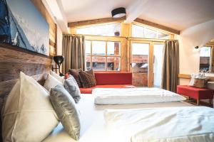 a bedroom with two beds and a red couch at CORE Kaprun in Kaprun +78 photos