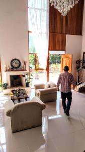 a man walking through a living room with furniture at Villa Amaranto Oxapampa in Oxapampa