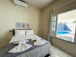 a bedroom with a bed and a large window at Casa da Lua in Barreirinhas +47 photos