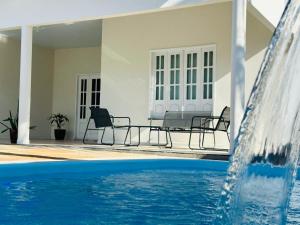 a swimming pool with chairs and a water fountain at Casa da Lua in Barreirinhas