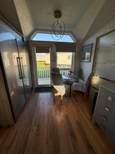 a living room with a table and chairs and a window at Summer Meadows at Sandy Bay in North Seaton