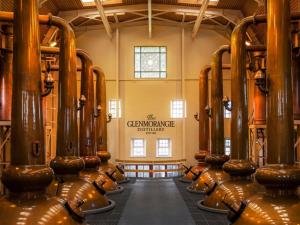 a room with rows of wine barrels in a building at Full Pint in Tain