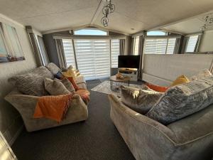 a living room with two couches and a television at Summer Meadows at Sandy Bay in North Seaton