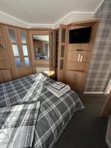 a bedroom with a bed and a flat screen tv at Summer Meadows at Sandy Bay in North Seaton