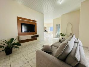 a living room with a couch and a flat screen tv at Casa da Lua in Barreirinhas