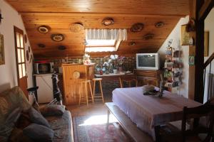 ein Zimmer mit einem Wohnzimmer und einer Küche mit einem Tisch in der Unterkunft Chambre d'Hôtes "Orchidees" in Nogent-le-Rotrou