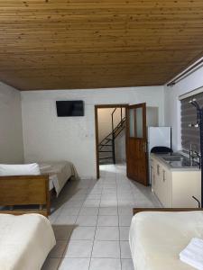 a room with two beds and a kitchen and a staircase at Holiday Guest-House in Përmet