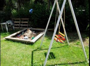 a sandbox with toys in it in the grass at Penzion Mirja in Hodkovice