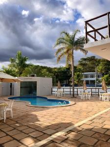 a patio with chairs and a swimming pool at Pousada Monte das Colinas in Montezuma