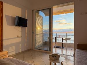 a living room with a view of a balcony at Fane's Apartments in Himare