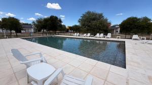 a swimming pool with chairs and a table and avisor at Complejo Sol y Sombra in San Javier +16 photos