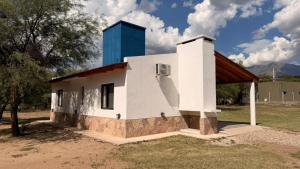 a small white building with a blue tower in a field at Complejo Sol y Sombra in San Javier