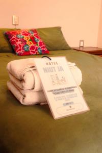 a book sitting on top of a bed with a towel at HOTEL NIUT-JA in Oaxaca City +12 photos