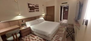 a bedroom with a white bed and a television at Palacio Valderrabanos in Ávila
