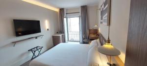 a hotel room with a bed and a television at Palacio Valderrabanos in Ávila